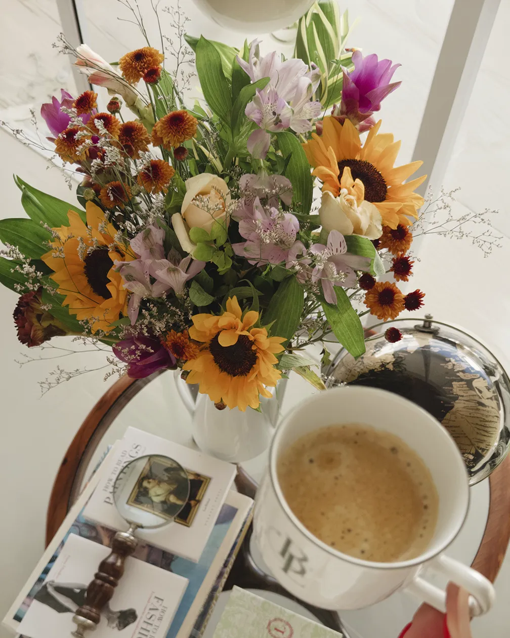 Buquê da Quintal Belém ao lado de café e livros
